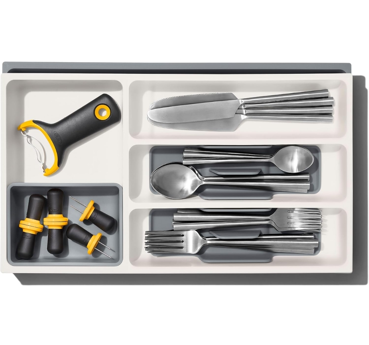 OXO Good Grips expandable drawer divider organizing utensils in a small kitchen drawer